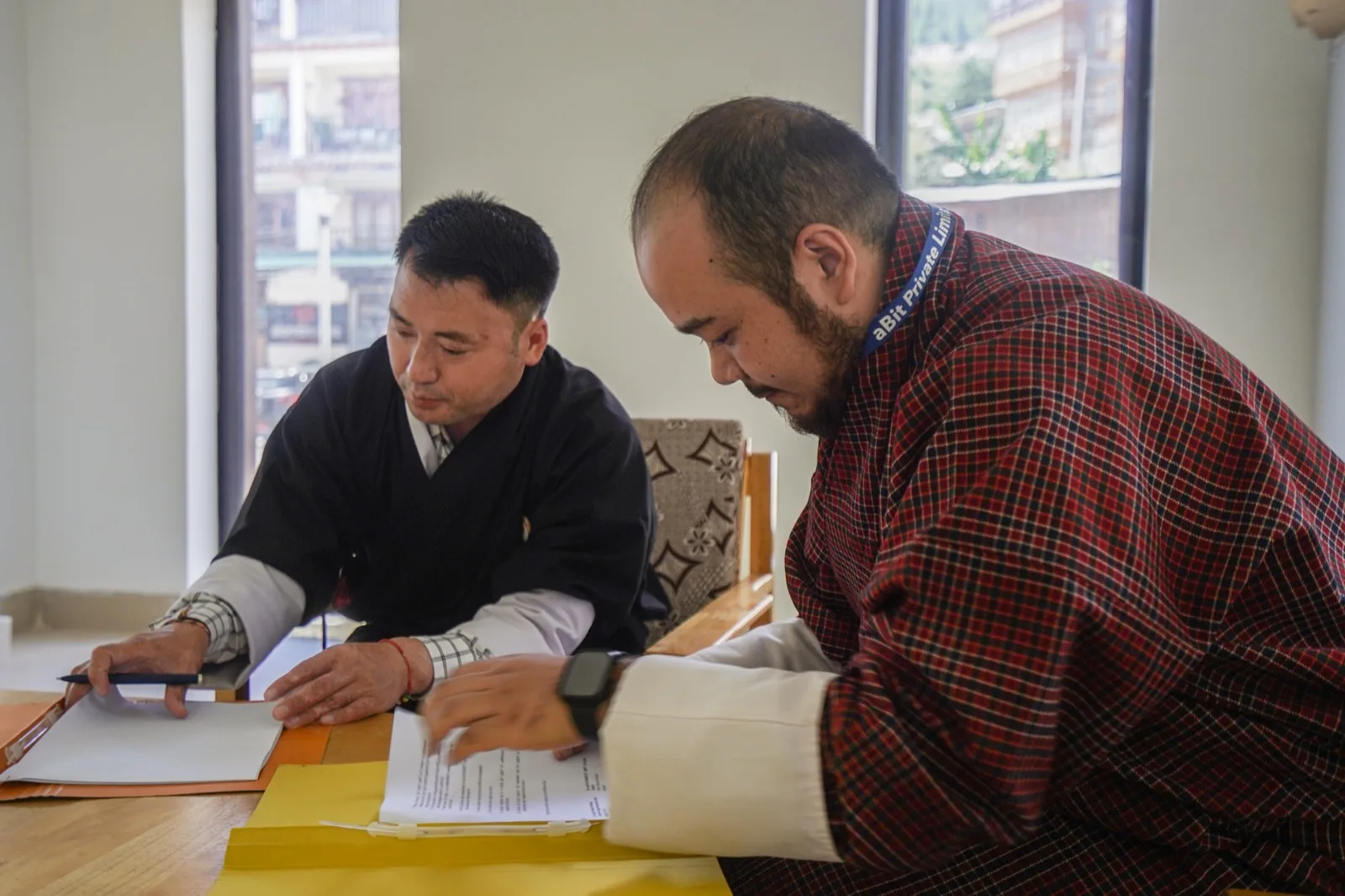 Drangpon Tenzin, Secretary General of BADRC, and Sameer Pradhan, Manager at aBit Private Limited, reviewing the Service Agreement at the Centre's office in Thimphu