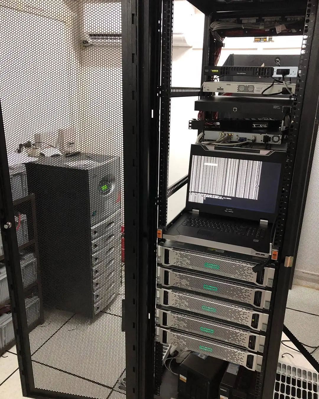 Rack-mounted servers with a pull-out KVM console displaying system output in a client server room