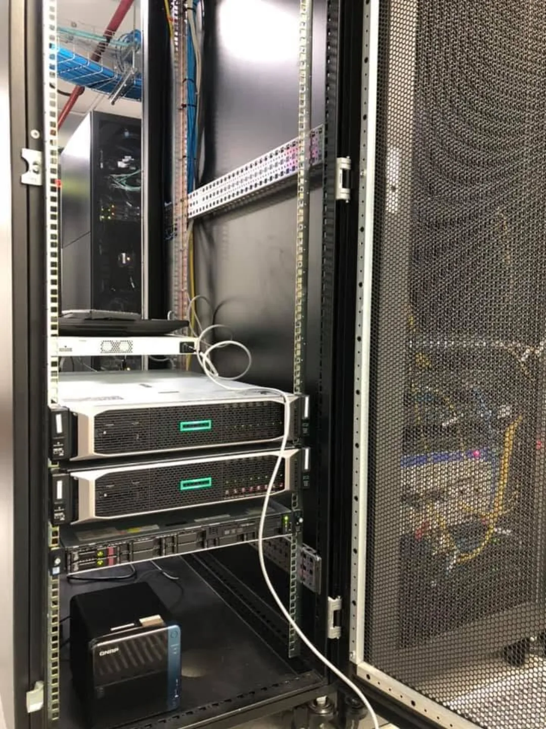 Rack-mounted servers with a network attached storage unit installed below them in a client data room