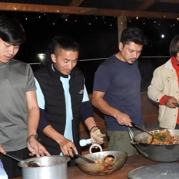 Four of the team cooking dinner together at an evening camp