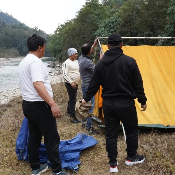 Pitching a tent beside the river on a camping trip