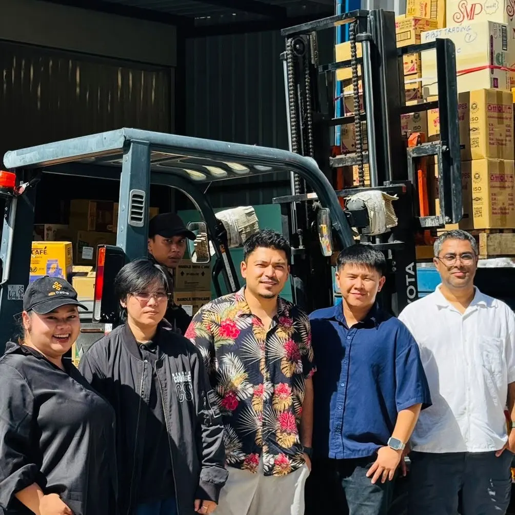 The aBit Trading team at the Bangkok warehouse, with a loaded pallet on the forklift behind them