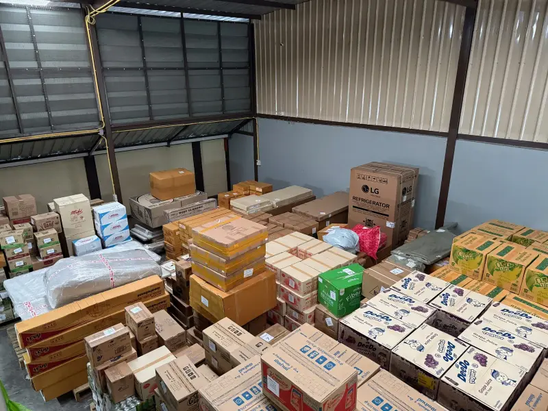 Cartons of mixed Thai consumer goods stacked inside the Bangkok warehouse ahead of consolidation